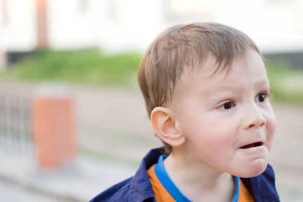 Kleiner blonder Junge macht lustige Gesichter — Stockfoto