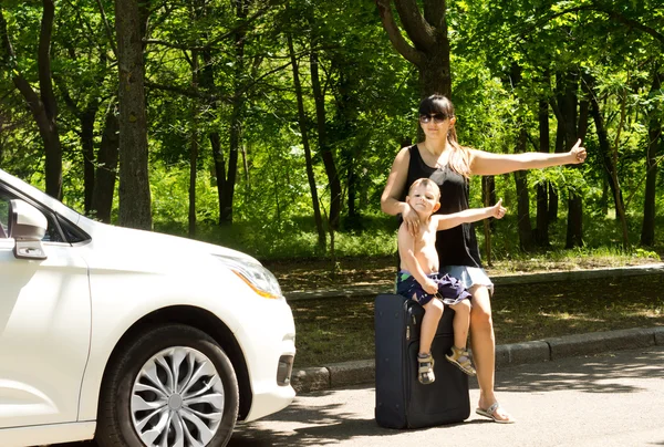 Jonge moeder vraagt om een lift door langs de weg — Stockfoto