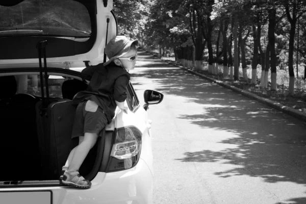 Playful boy standing in the open truck of a car — Stock Photo, Image