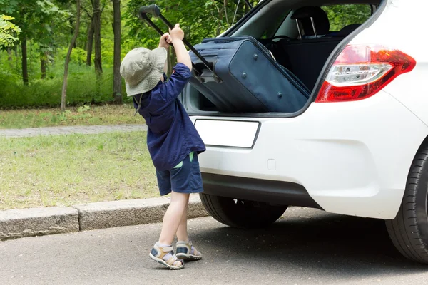 Netter kleiner Junge lädt seinen Koffer — Stockfoto