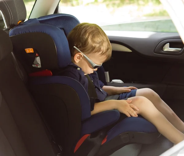 Young small boy sleeping in a child car-seat — Stock Photo, Image