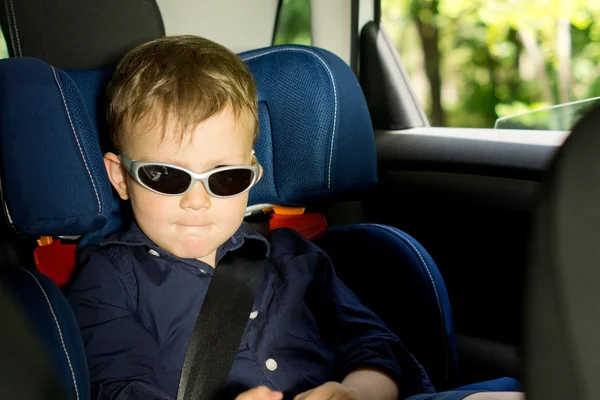 Νεαρό αγόρι κάθεται σε ένα κάθισμα αυτοκινήτων παιδί — Φωτογραφία Αρχείου
