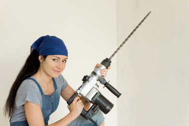 bir elektrikli matkap tutan genç DIY kadın