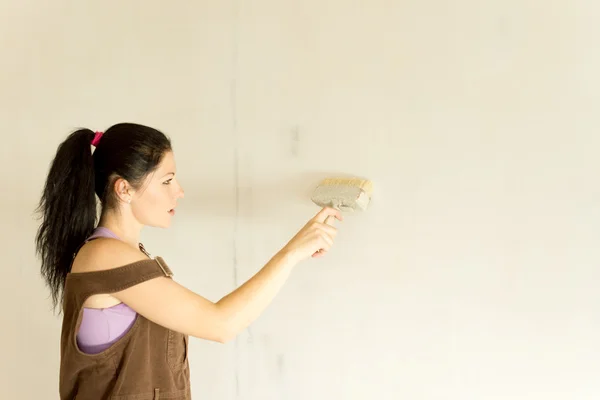 Young attractive woman decorating walls — Stock Photo, Image