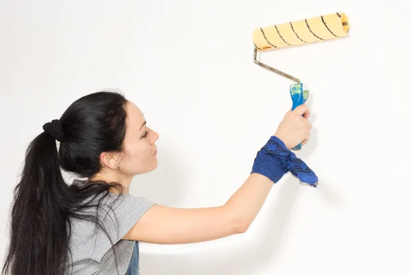Donna che dipinge un muro con un rullo — Foto Stock
