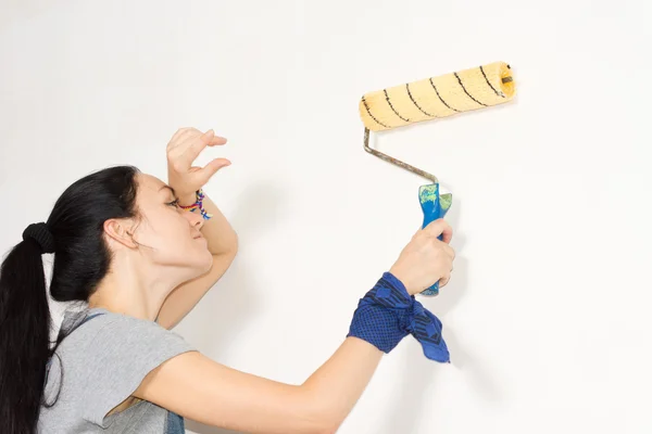 Vrouw haar voorhoofd afvegen zoals ze een muur schildert — Stockfoto
