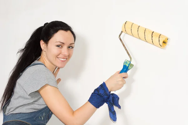 Mujer sonriente pintando su casa — Foto de Stock