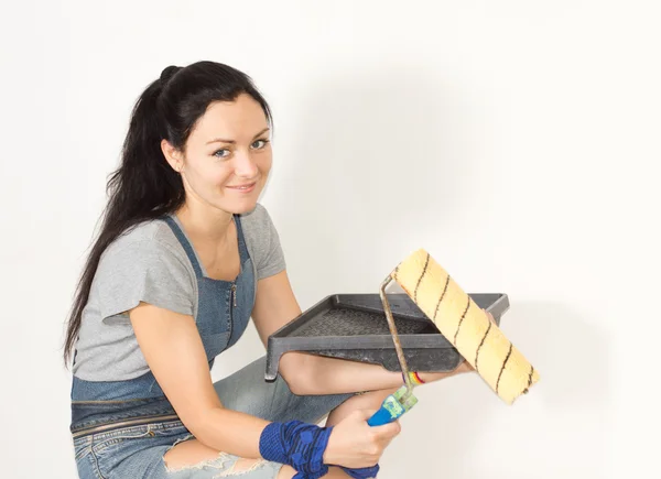 Lachende vrouw met een verf lade en roller — Stockfoto