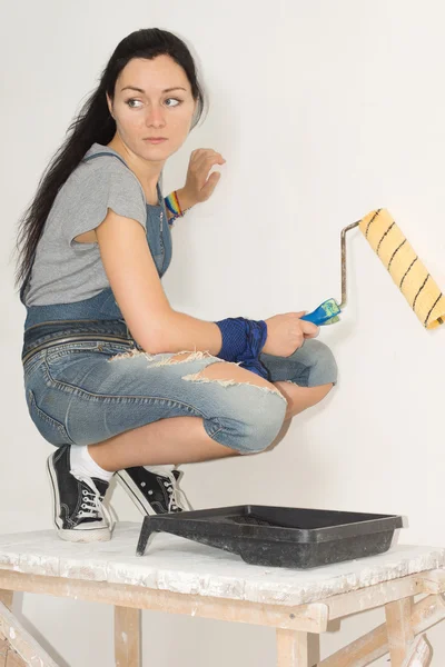 Donna che dipinge la sua casa con un rullo — Foto Stock