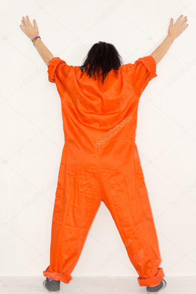 Woman standing displaying her orange overalls