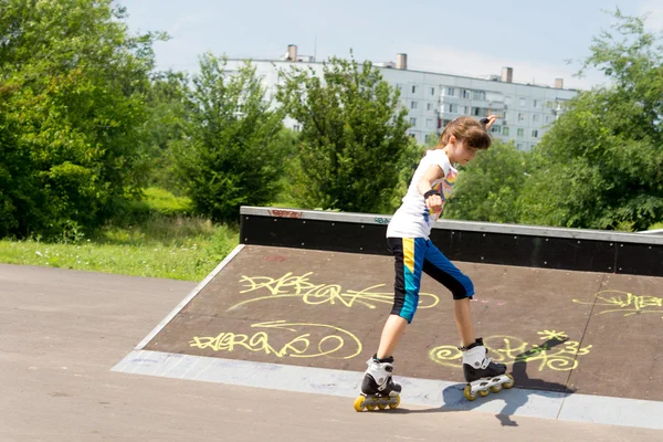 Ragazza adolescente pattinaggio a rotelle in un parco — Foto Stock