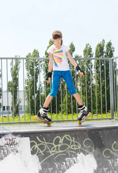 Junges Mädchen in Rollerblades auf einer Rampe — Stockfoto