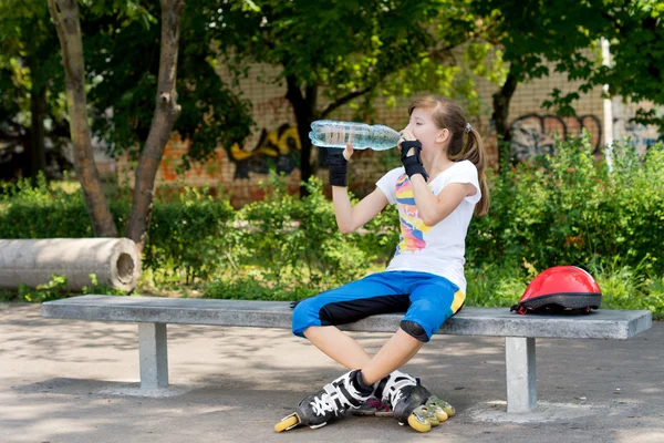 Teenage roller skater pausing for a drink — Stock Photo, Image