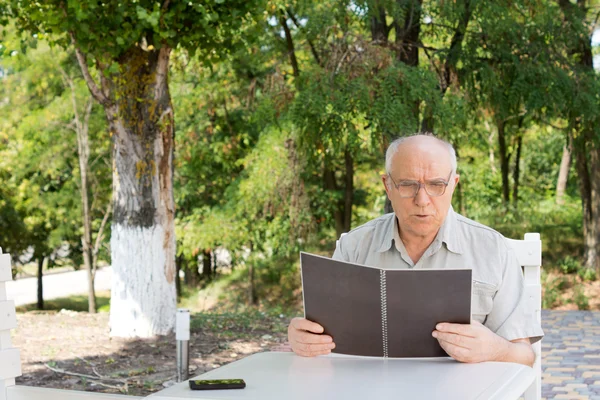 Reifer Mann liest Speisekarte im Restaurant — Stockfoto