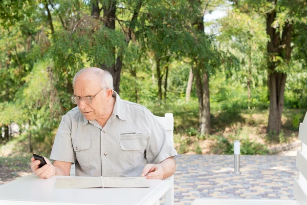 Elderly man texting on his mobile — Stock Photo, Image