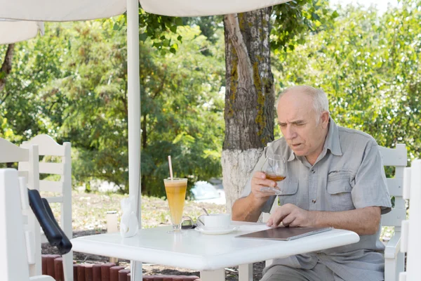 Homme âgé profitant d'un snifter de cognac — Photo