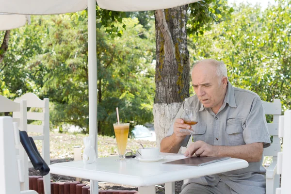 Senior genießt einen Schnupfen von Cognac — Stockfoto