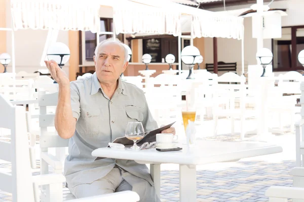Oudere man samenroepen van een ober — Stockfoto