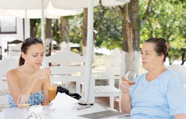 Mãe e filha tomando bebidas — Fotografia de Stock