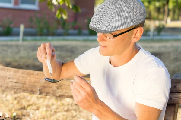 Man filling a syringe with injectable heroin — Stock Photo, Image