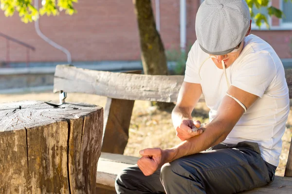 Addicted man injecting himself a dose of drug — Stock Photo, Image