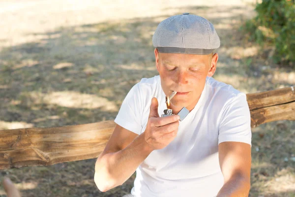 Caucasian man lighting a cigarette while relaxing — Stock Photo, Image