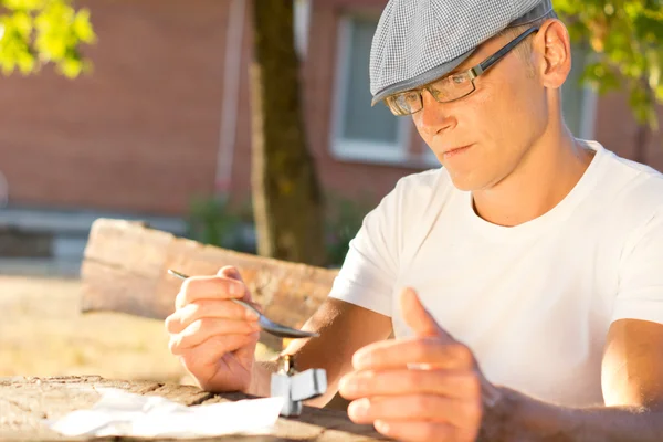 Drug user preparing a dose for an injection — Stock Photo, Image