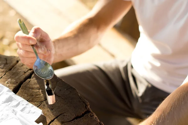 Hände eines Mannes, der Kokainpuder erhitzt — Stockfoto