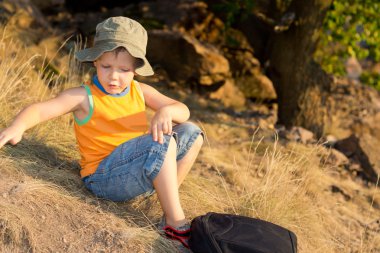 bir sırt çantası ile oturan küçük çocuk