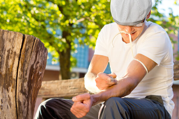 Drug male addict injecting himself with heroine