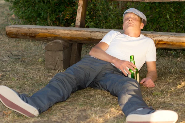 Alcoholische passed out op de grond in een park — Stockfoto