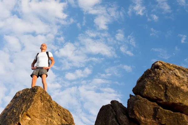 Man standing on a tall rock surveying the world — Stock Photo, Image