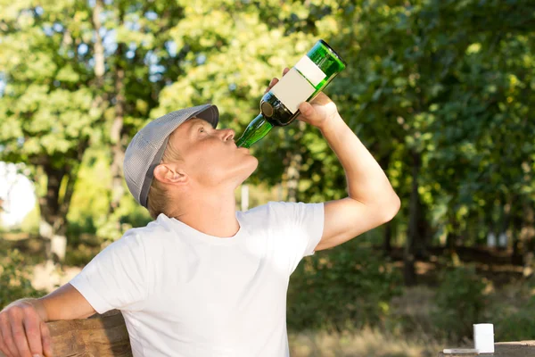 Alcohol abuser drinking from a bottle of wine — Stock Photo, Image