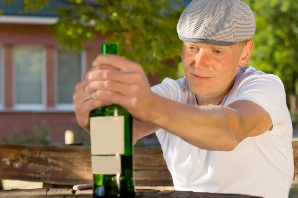 Alkoholické muž pocit závratě, sedí u stolu — Stock fotografie