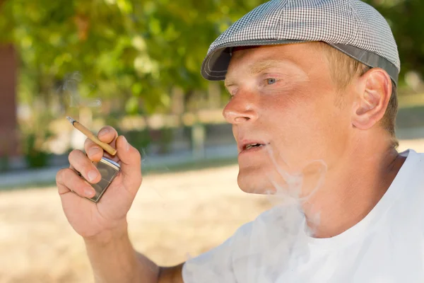 Man een huis warmgewalste sigaret roken — Stockfoto
