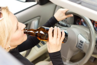 Drunk woman imbibing as she drives clipart