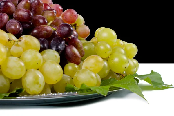 Röda och gröna druvor på en tallrik — Stockfoto