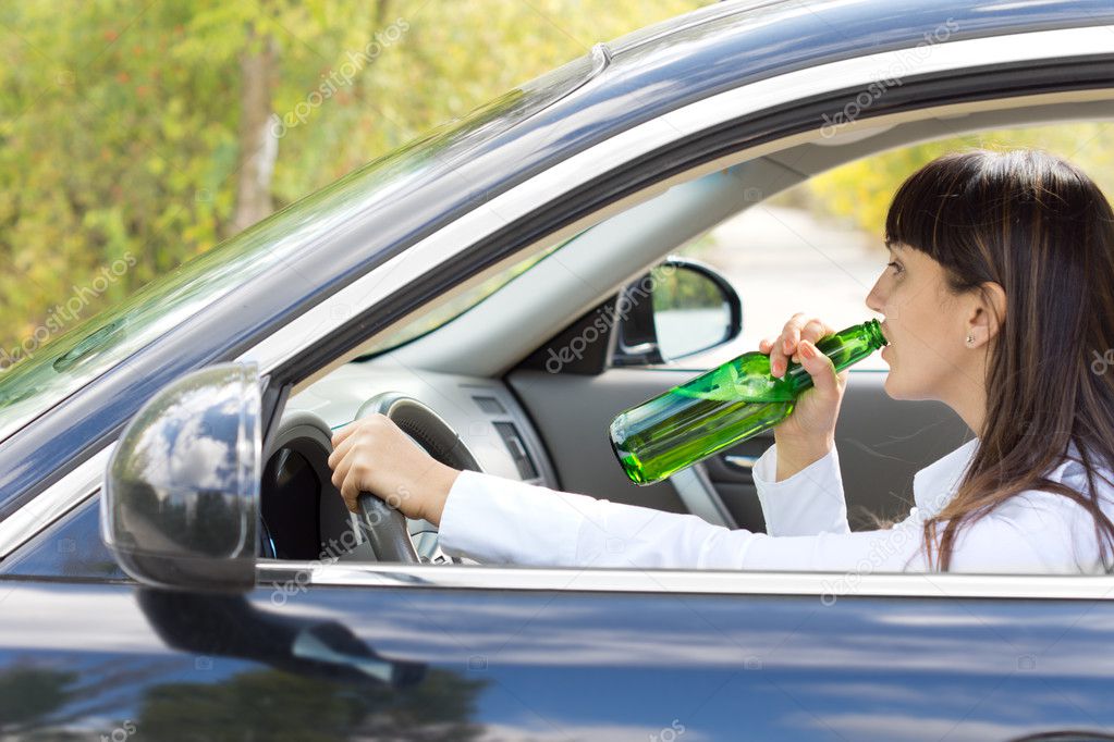 Inebriated female driver drinking alcohol