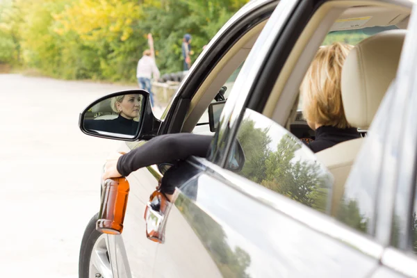 Betrunkene Frau baumelt mit Flasche vor Auto — Stockfoto