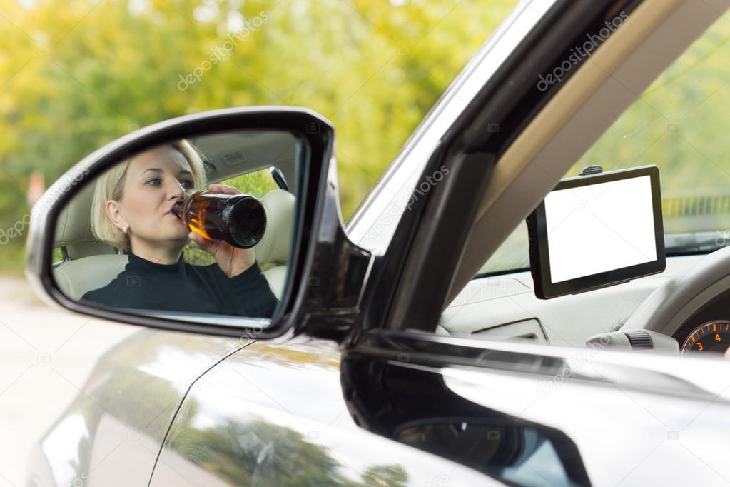 Female driver drinking as she drives