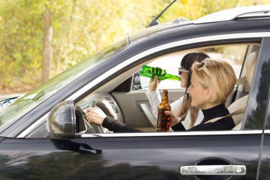 Two women driving a car while drinking clipart