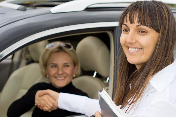 Lächelnde Verkäuferin gratuliert dem neuen Besitzer — Stockfoto