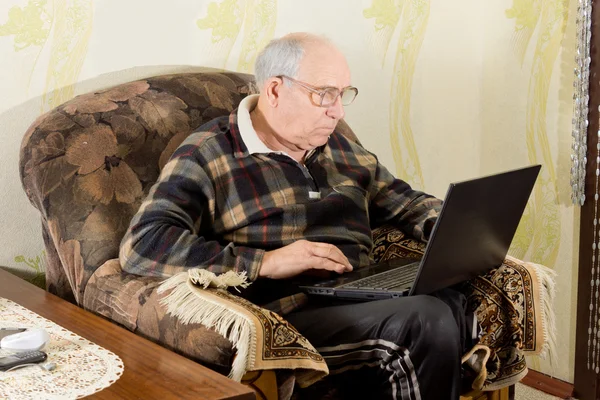 Idoso navegando na internet em um laptop — Fotografia de Stock