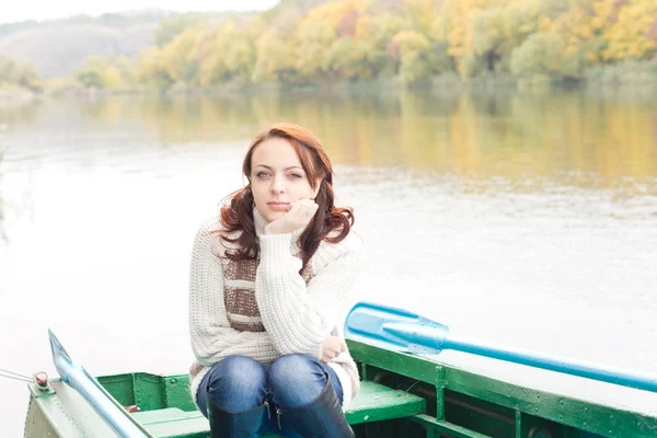 Pretty young woman sitting in a rowboat — Stock Photo, Image