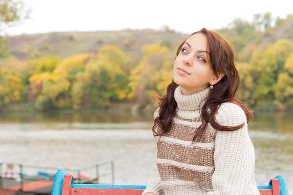 Attractive teenage girl sitting at a lake — Stock Photo, Image