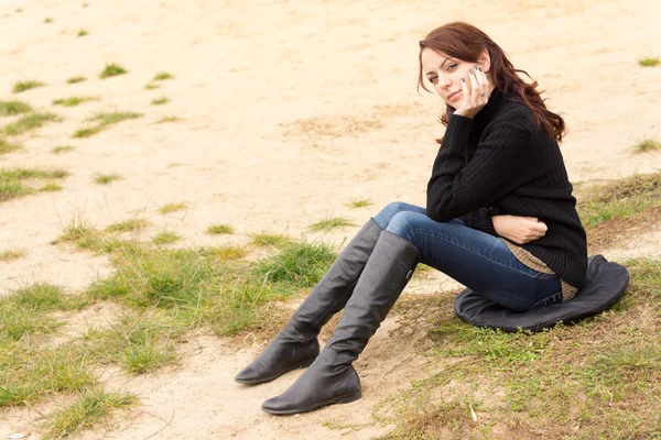 Mujer joven y triste sentada al aire libre sola — Foto de Stock