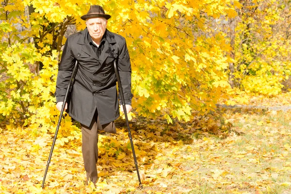 Deficiente idoso amputado masculino em um parque de queda — Fotografia de Stock