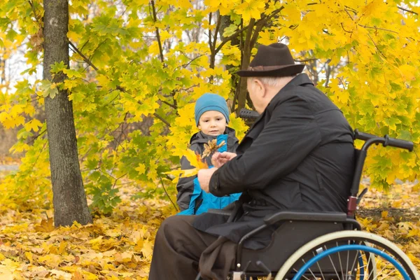 Kleiner Junge mit seinem behinderten Großvater — Stockfoto