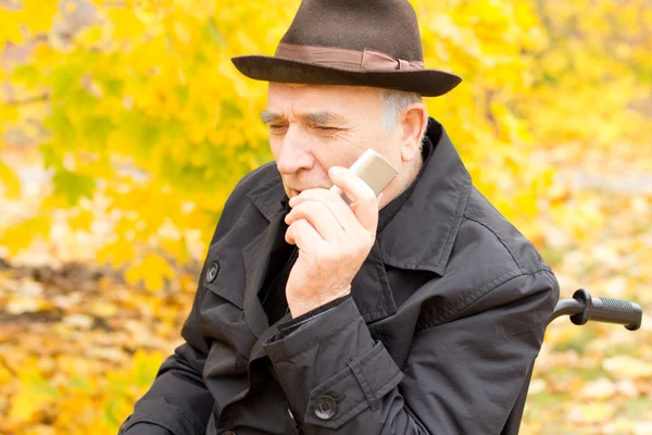 Hombre mayor sosteniendo un teléfono móvil — Foto de Stock