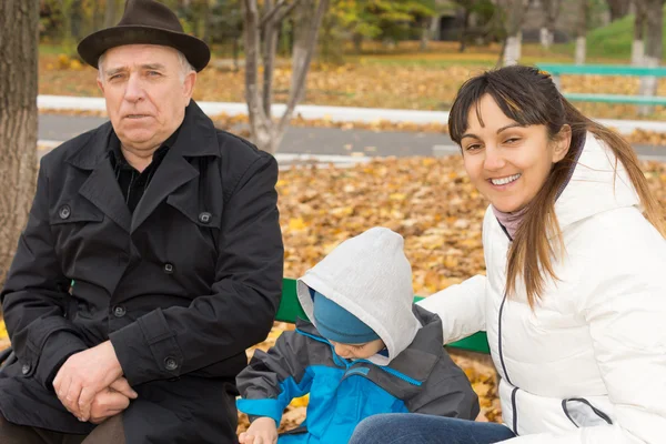 Mujer amigable sonriente con su hijo y su padre —  Fotos de Stock